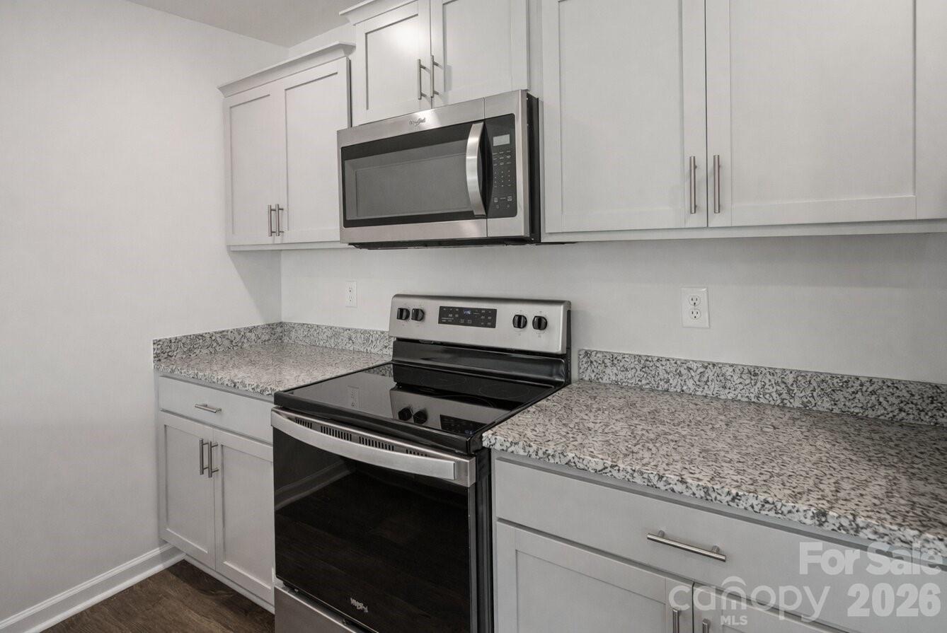 6109 Faron Way Charlotte, NC 28262 - Photo 4 of 23 a kitchen with granite countertop white cabinets stainless steel appliances and a sink