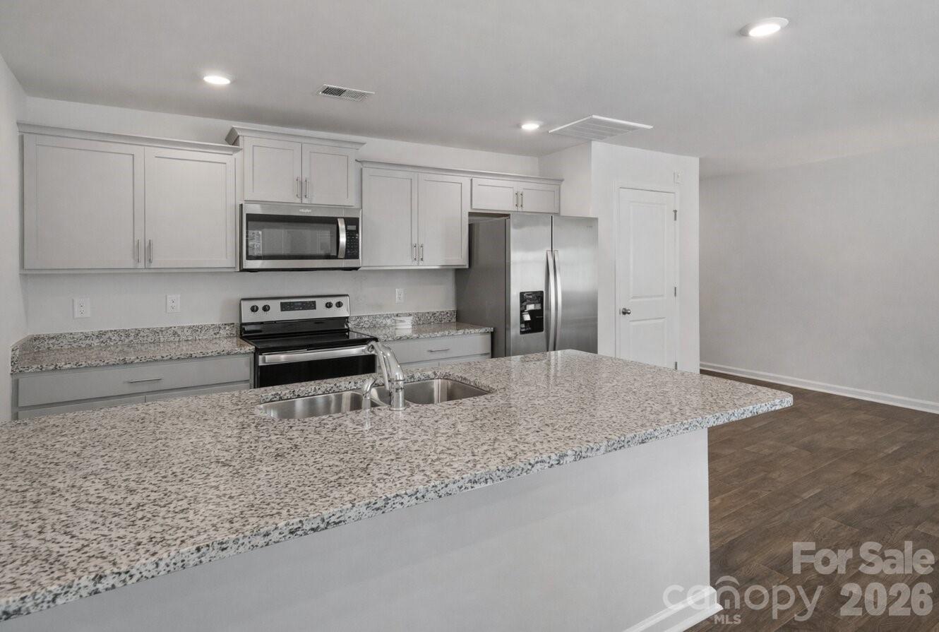 6109 Faron Way Charlotte, NC 28262 - Photo 5 of 23 a kitchen with stainless steel appliances granite countertop a sink a stove a microwave and a refrigerator