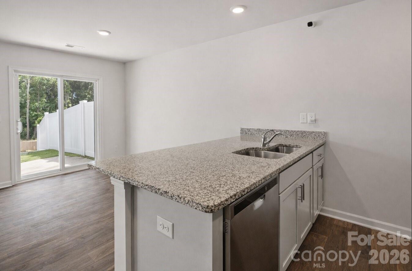 6109 Faron Way Charlotte, NC 28262 - Photo 7 of 23 a utility room with granite countertop a sink and a wooden floor