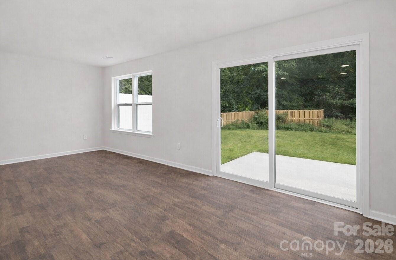 6109 Faron Way Charlotte, NC 28262 - Photo 9 of 23 a view of an empty room with wooden floor and a floor to ceiling window