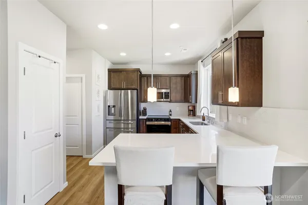 a kitchen with kitchen island a sink stove and refrigerator