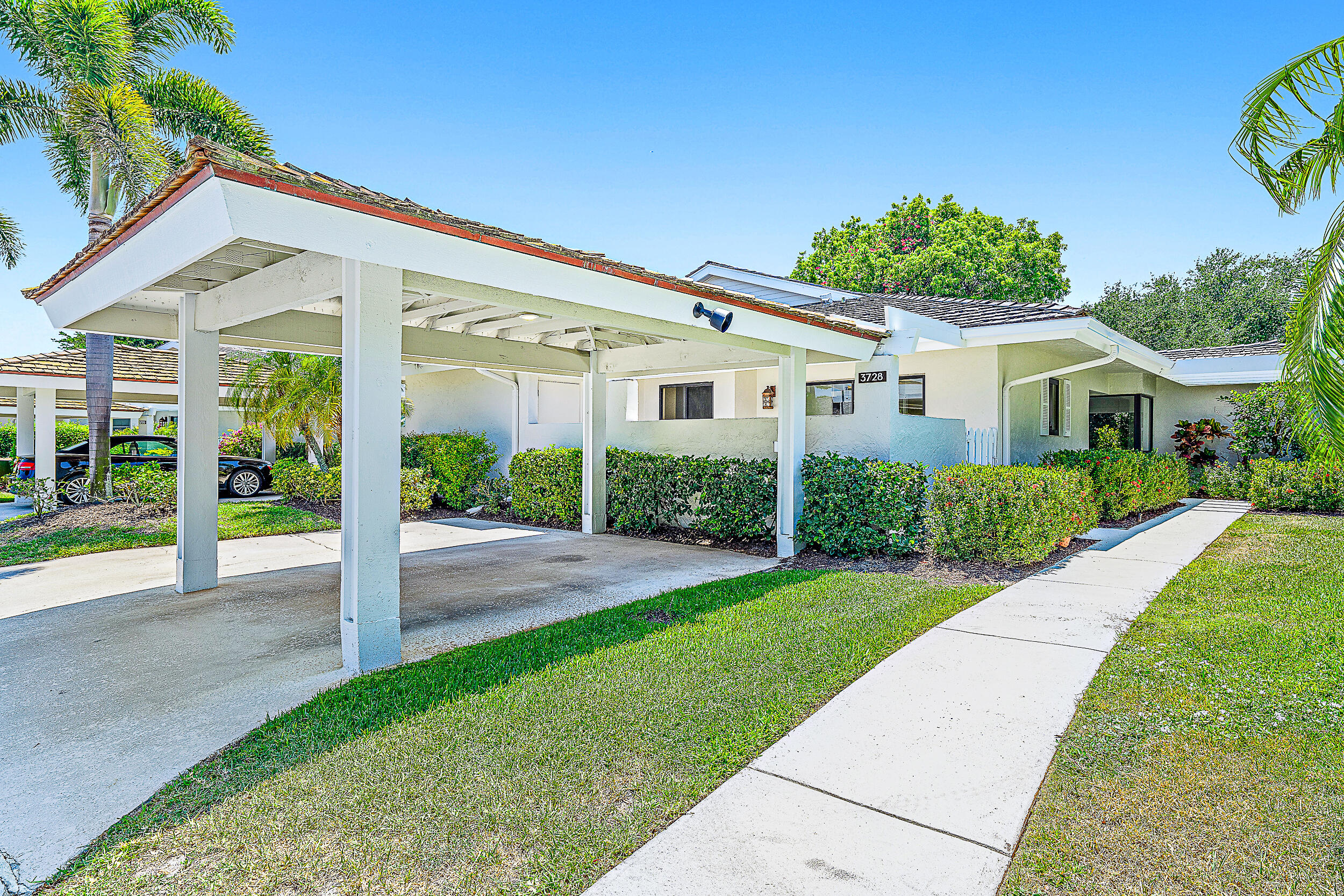 Undisclosed Address Jupiter, FL 33477 - Photo 25 of 30 a front view of a house with a yard and potted plants