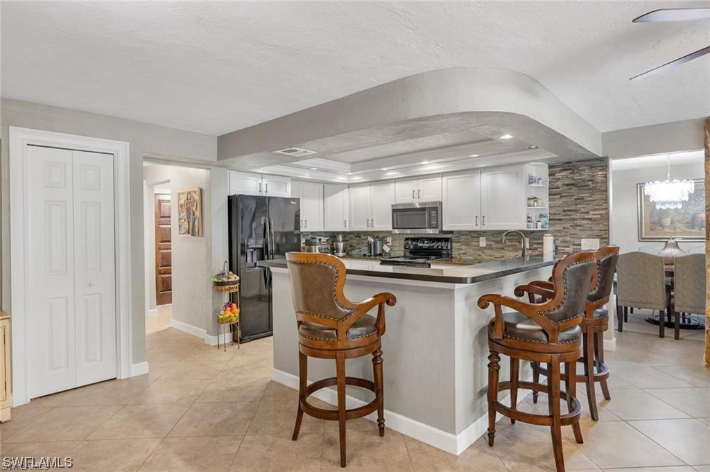 13951 River Road Fort Myers, FL 33905 - Photo 11 of 34 a kitchen with stainless steel appliances granite countertop a dining table chairs refrigerator and sink