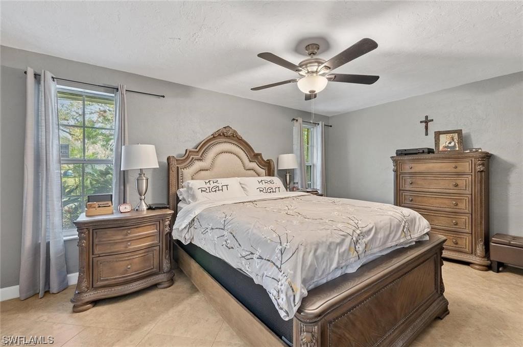 13951 River Road Fort Myers, FL 33905 - Photo 15 of 34 a bedroom with a bed and a chandelier