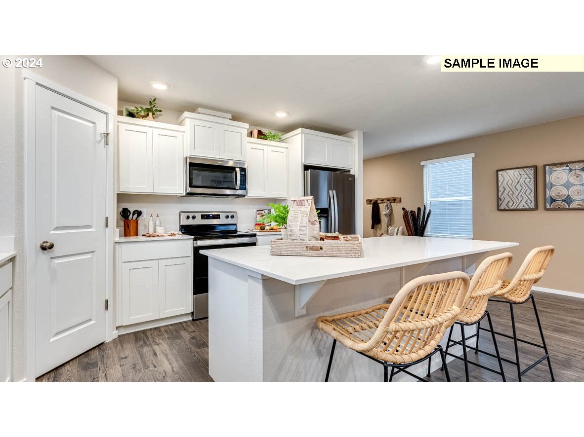 812 Northwest 175th Street Ridgefield, WA 98642 - Photo 7 of 25 a kitchen with a table chairs a refrigerator and a sink