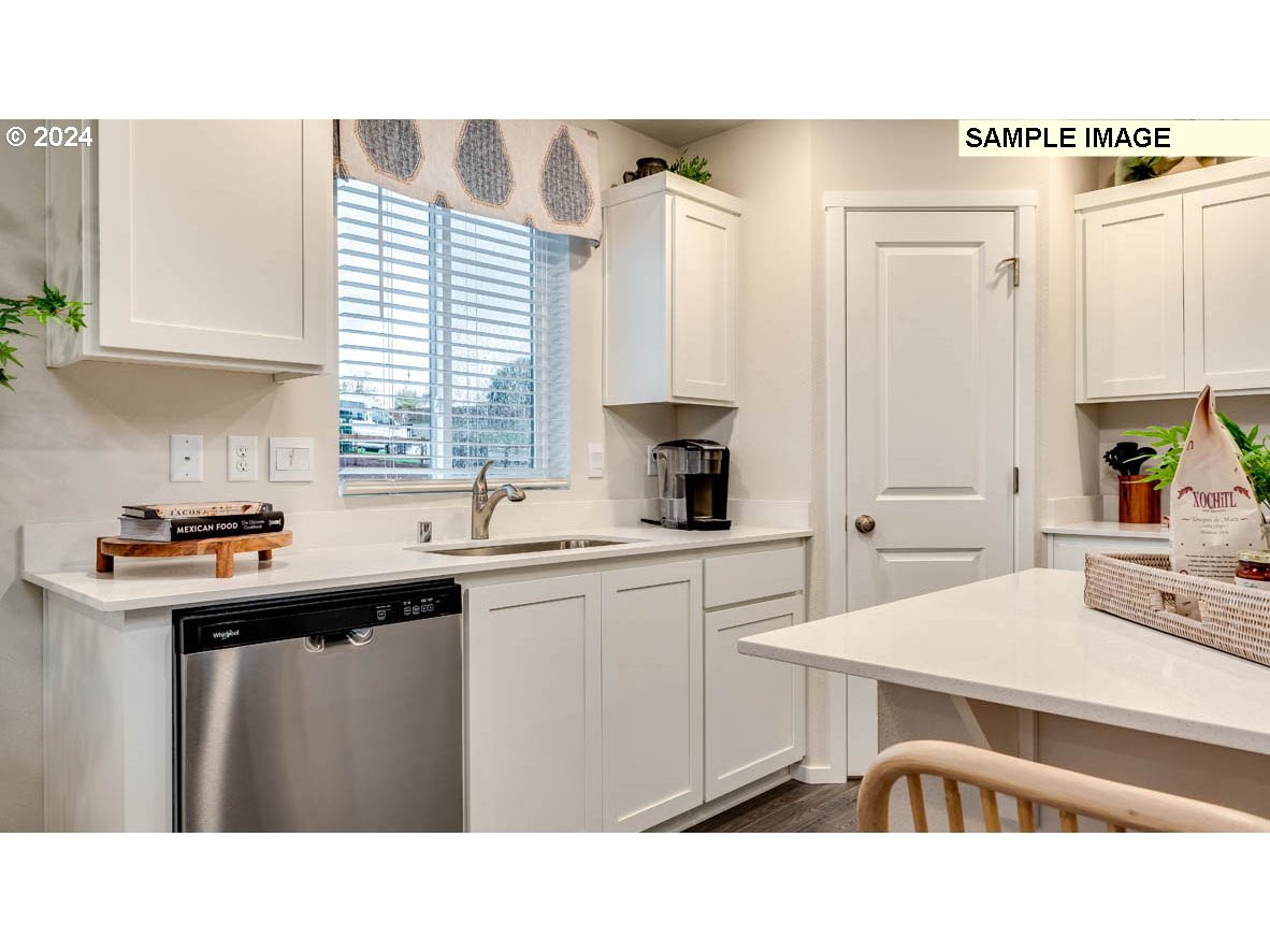 812 Northwest 175th Street Ridgefield, WA 98642 - Photo 10 of 25 a kitchen with a table chairs sink and cabinets