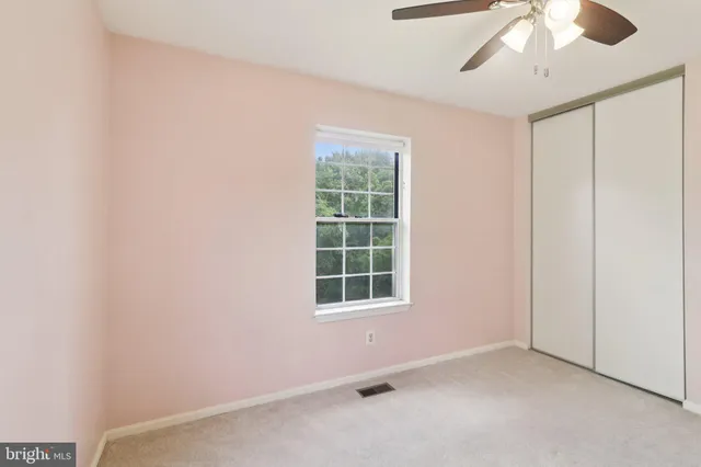 an empty room with a cabinet and mirrors