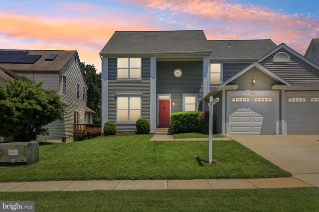 an empty room with wooden floor closet and windows