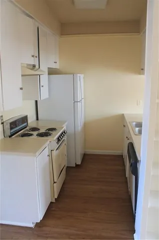 a kitchen with a stove top oven a sink and a refrigerator