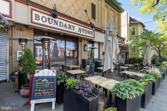 a store with outdoor seating area and flowers