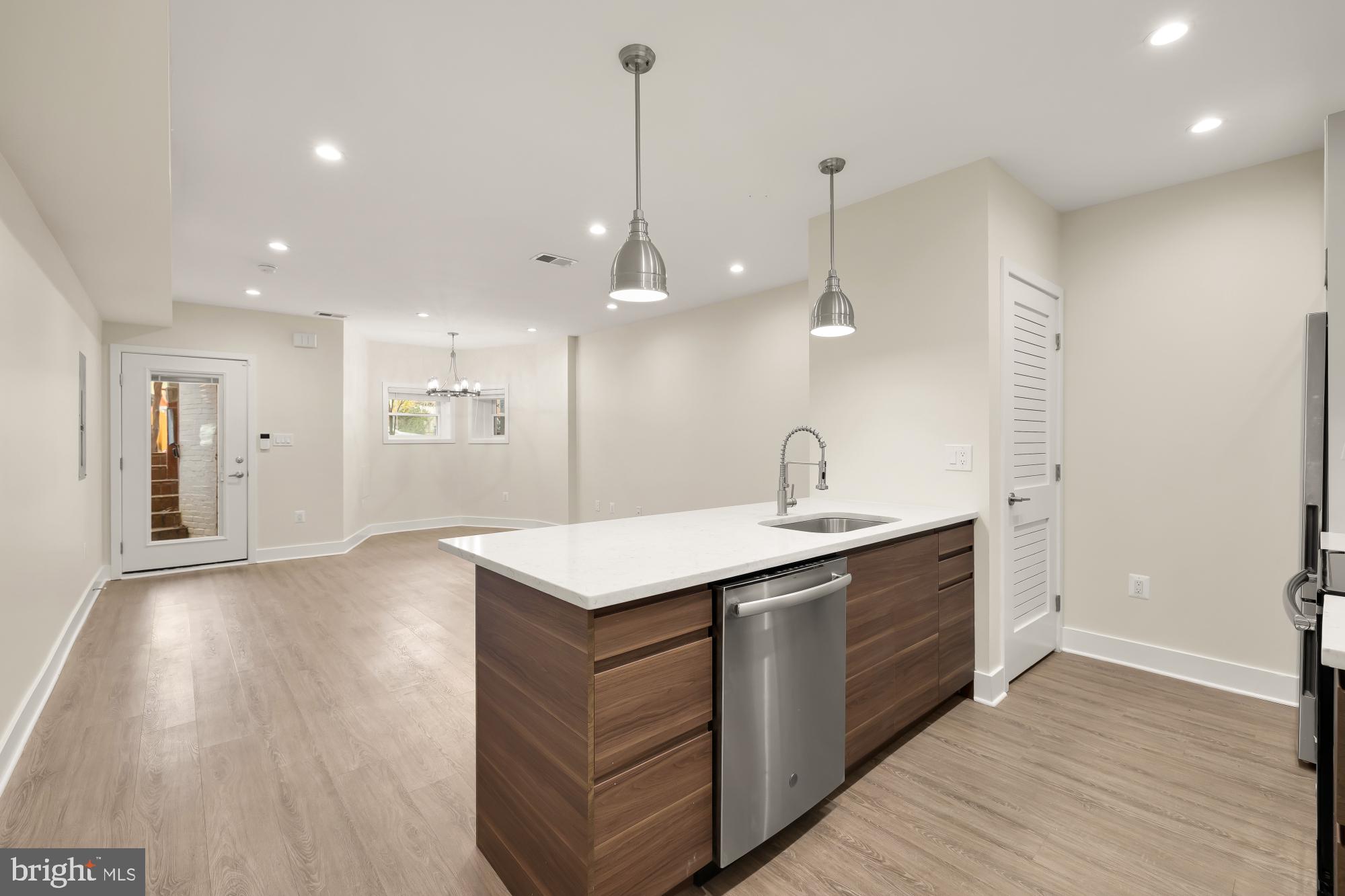 58 T Street Northwest, Unit 1 Washington, DC 20001 - Photo 7 of 27 a kitchen with a sink a window stainless steel appliances and cabinets