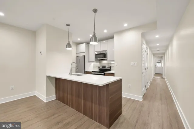 a kitchen with kitchen island a sink and a stove top oven