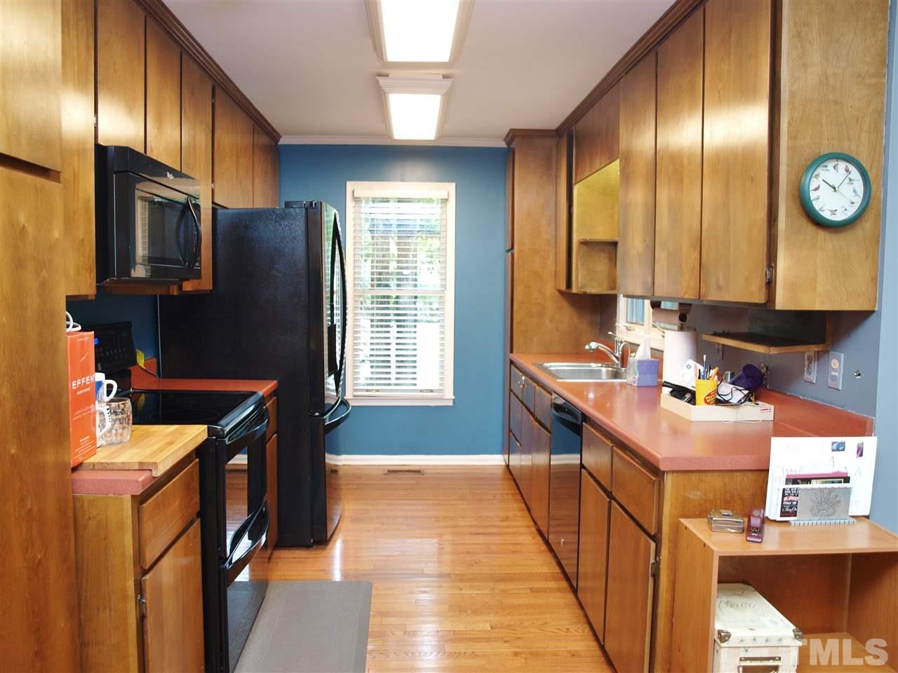 2955 Rue Sans Famille Raleigh, NC 27607 - Photo 7 of 21 a kitchen with stainless steel appliances granite countertop a sink stove and refrigerator