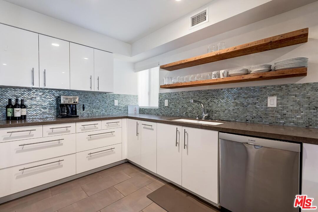858 12th Street, Unit 4 Santa Monica, CA 90403 - Photo 5 of 18 a kitchen with granite countertop white cabinets and white stainless steel appliances