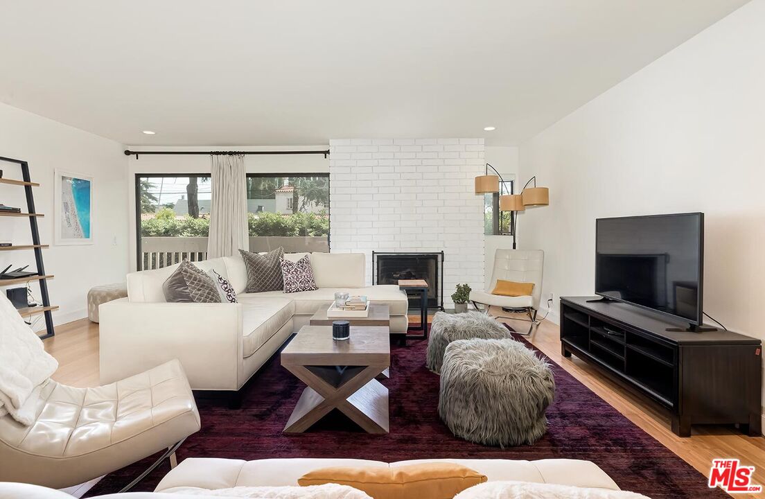 858 12th Street, Unit 4 Santa Monica, CA 90403 - Photo 8 of 18 a living room with furniture fireplace and a flat screen tv