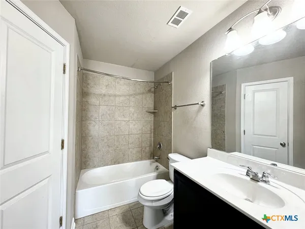 a bathroom with a sink a toilet a mirror and bathtub