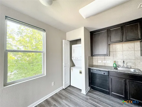 a kitchen with stainless steel appliances a sink cabinets and a window