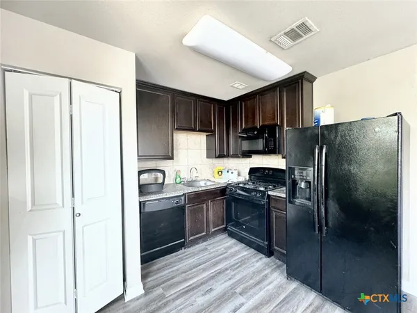 a kitchen with stainless steel appliances granite countertop a refrigerator and a stove