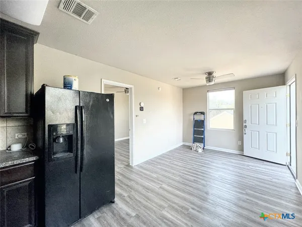 a view of a refrigerator in kitchen and wooden floor