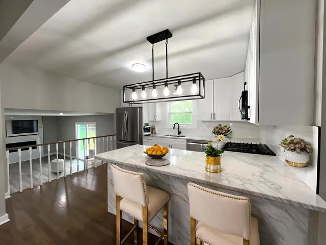 a kitchen with a sink a stove and chairs