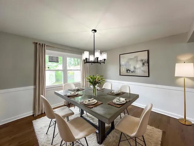 a dining room with furniture a chandelier and wooden floor