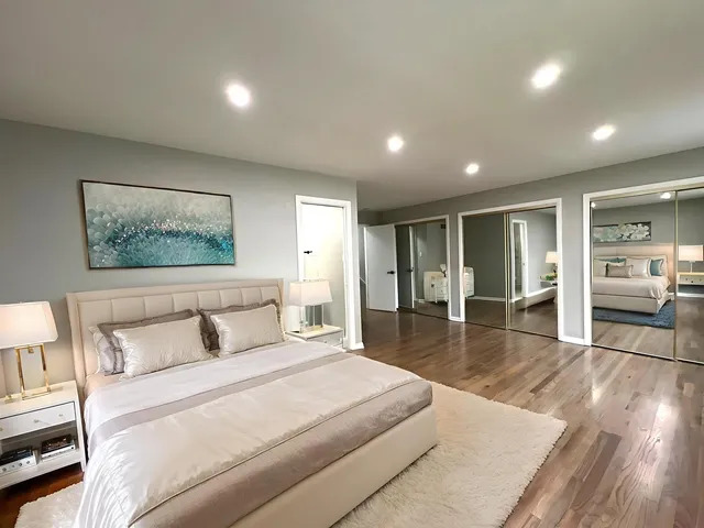 a spacious bedroom with a large bed and a wooden floor