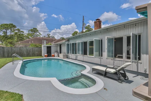 a view of a house with swimming pool and sitting area