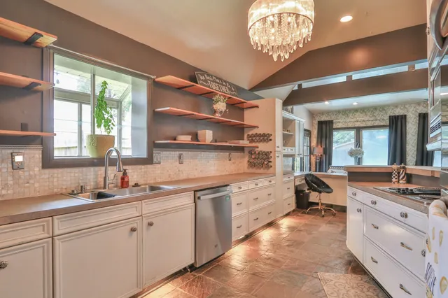 a living room with furniture and a view of kitchen