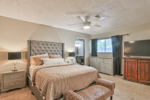 a bedroom with a bed and a flat tv screen on wall