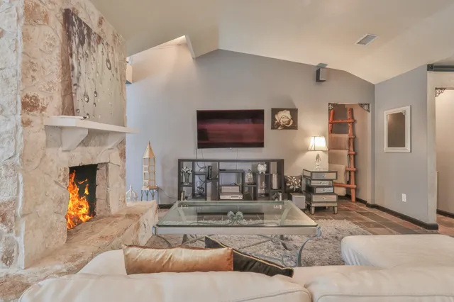 a living room with furniture a fireplace and a chandelier