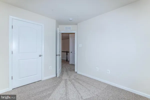 a view of an empty room and closet area