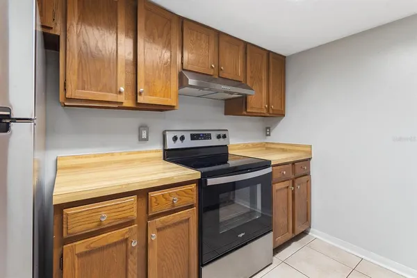 a kitchen with stainless steel appliances granite countertop wooden cabinets washer and dryer
