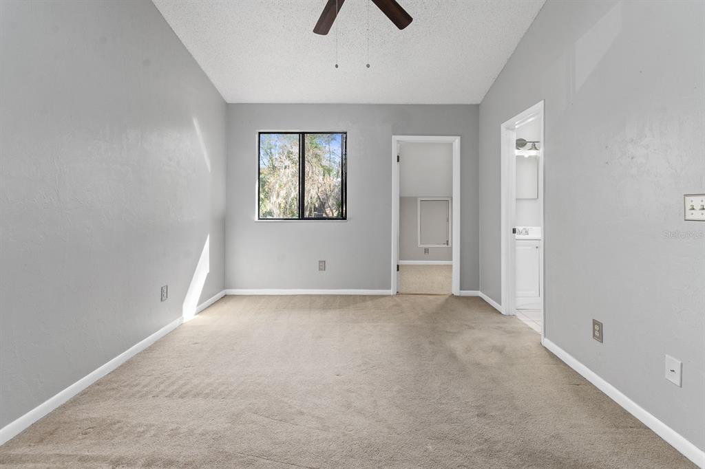 6926 Southwest 45th Avenue Gainesville, FL 32608 - Photo 17 of 28 an empty room with chandelier fan and windows