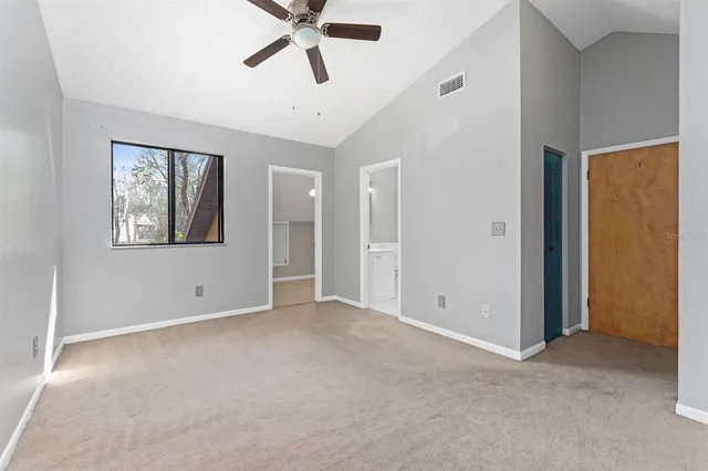 an empty room with windows and fan