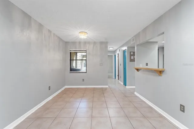 a view of an empty room with window and stairs