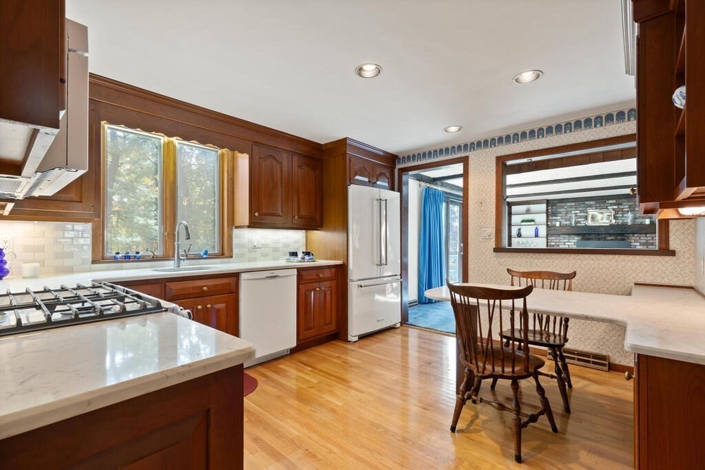 14 Parkerville Road Chelmsford, MA 01824 - Photo 8 of 34 a kitchen with stainless steel appliances granite countertop a stove top oven a sink dishwasher and a dining table with wooden floor