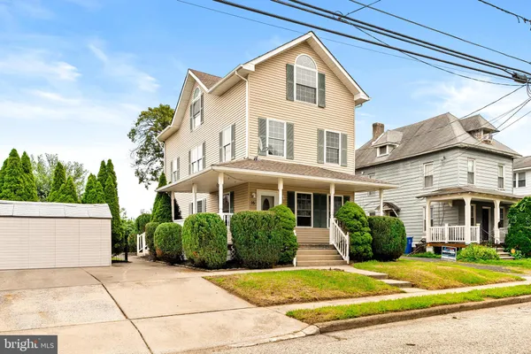 a view of yellow house with a small yard and plants