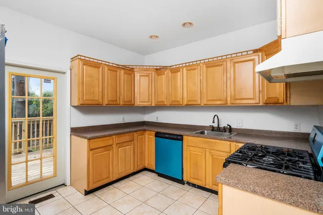 a kitchen with granite countertop a sink stove top oven and cabinets