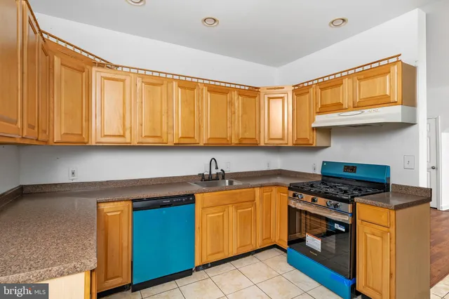 a kitchen with stainless steel appliances granite countertop a sink stove and cabinets