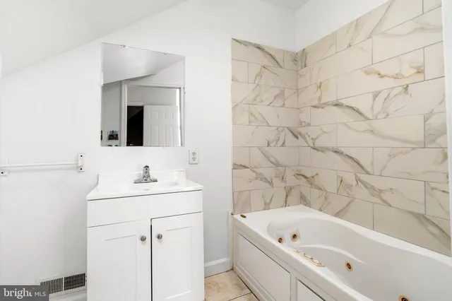 a bathroom with a tub sink and mirror