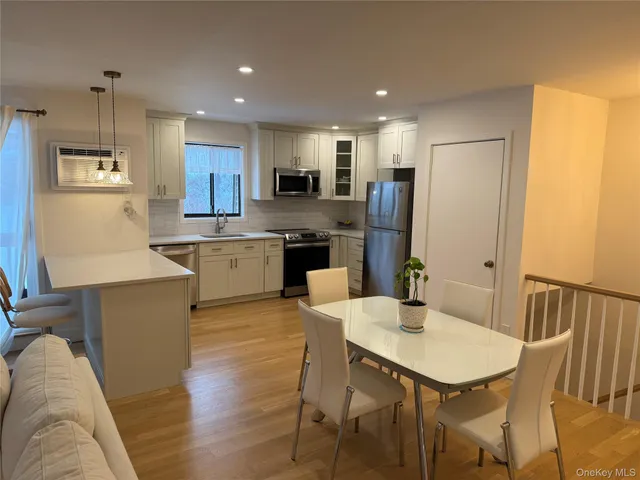 a kitchen with a table chairs refrigerator and microwave