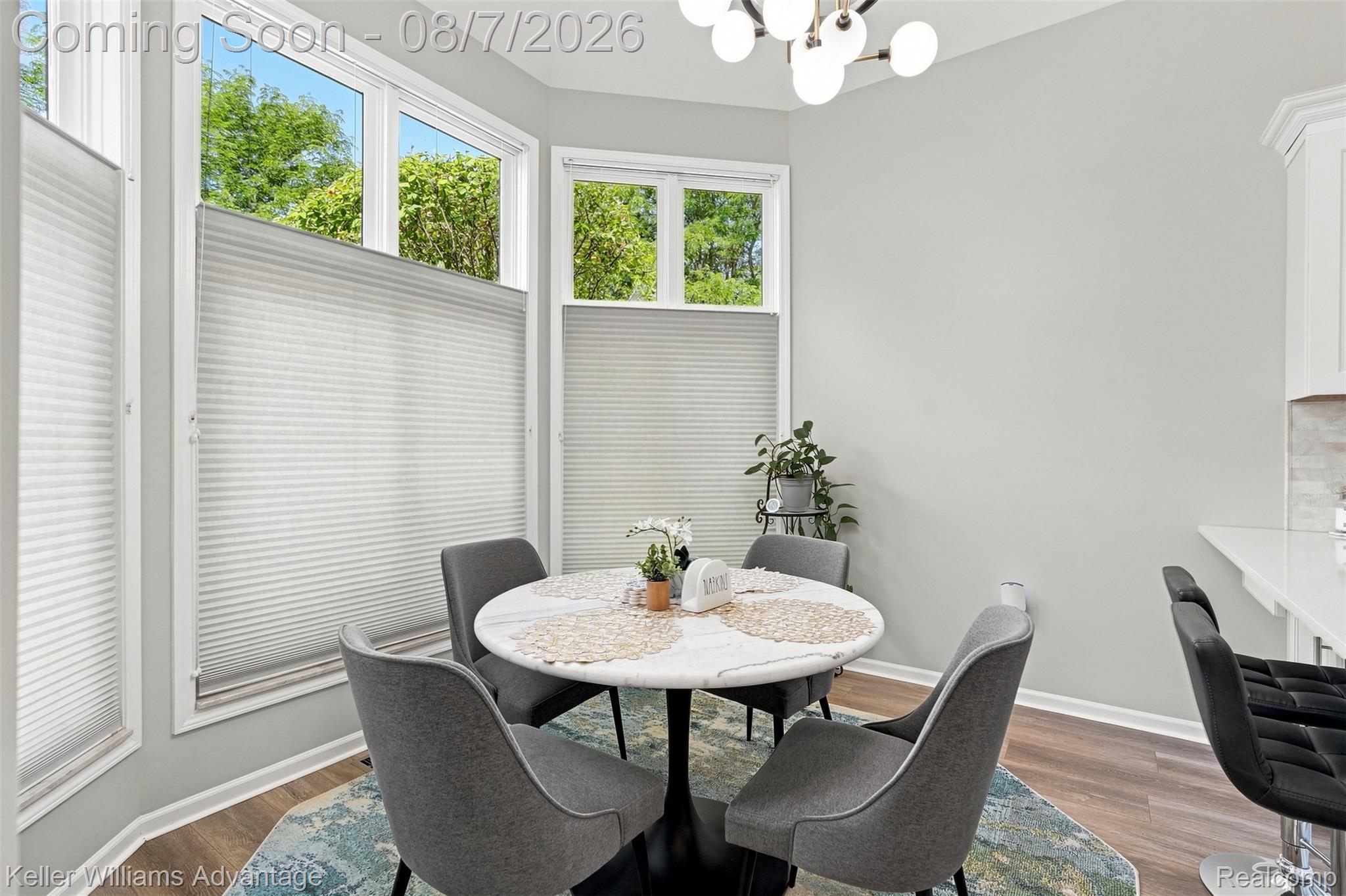 5325 Simpson Lake Road West Bloomfield, MI 48323 - Photo 15 of 43 Bay window dining area with cellular shades, a modern chandelier, and wood-finish flooring