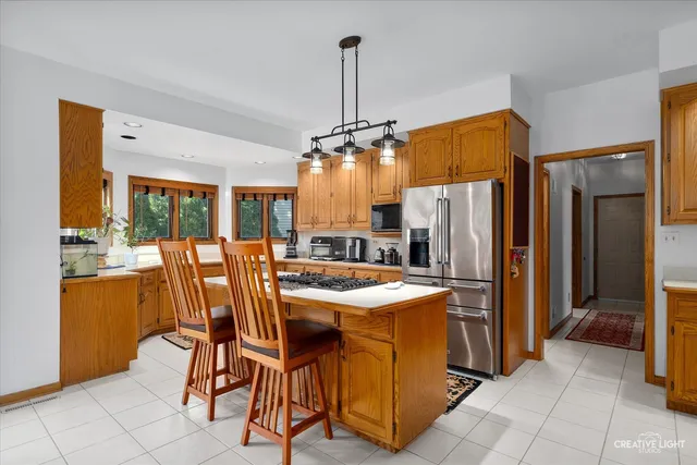 a dining table chair next to a window and a refrigerator