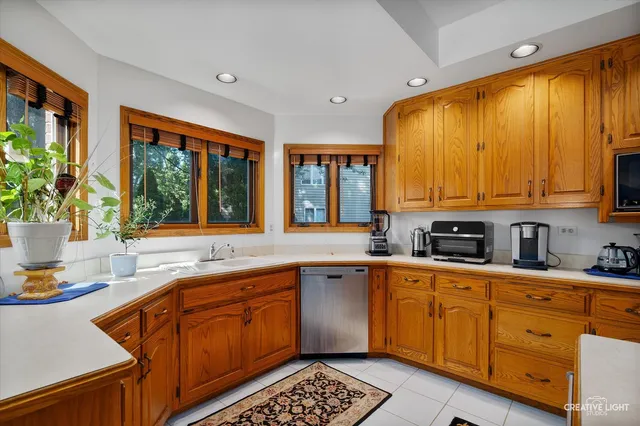 a kitchen with stainless steel appliances kitchen island granite countertop a sink window and cabinets