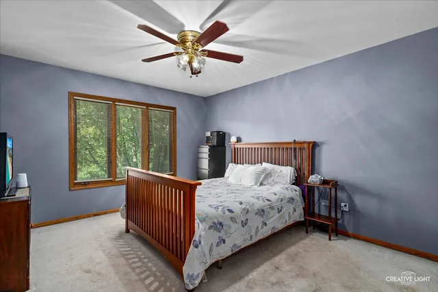 a bedroom with a bed chandelier and a window