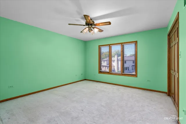 an empty room with windows and ceiling fan