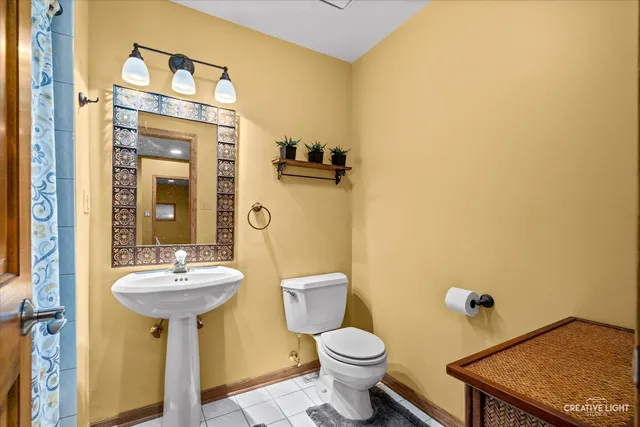 a bathroom with a sink a toilet and a mirror