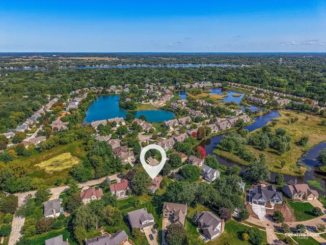 an aerial view of residential houses with outdoor space and trees