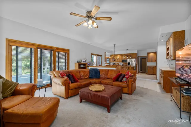 a living room with furniture ceiling fan and a flat screen tv