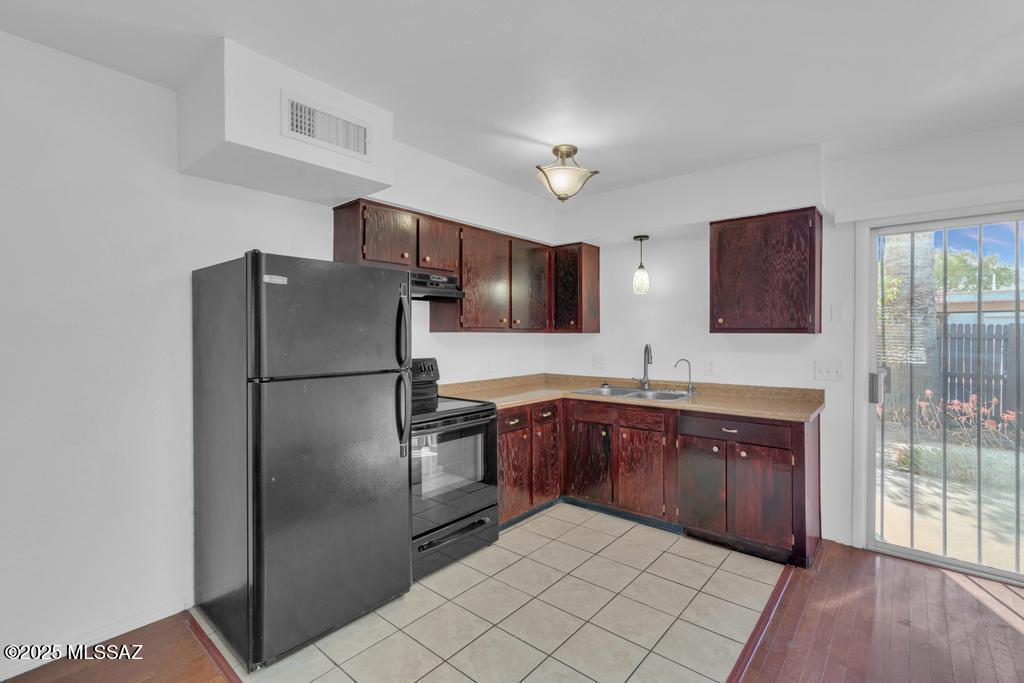 211 West Roger Road, Unit 35 Tucson, AZ 85705 - Photo 8 of 24 a kitchen with stainless steel appliances granite countertop a refrigerator sink and cabinets